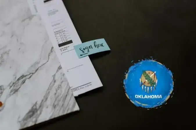 Real estate documents with dark background and Oklahoma flag