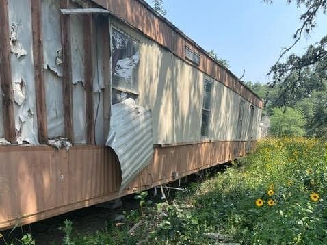 Abandoned mobile home on Kathy Tedder's property before cleanup
