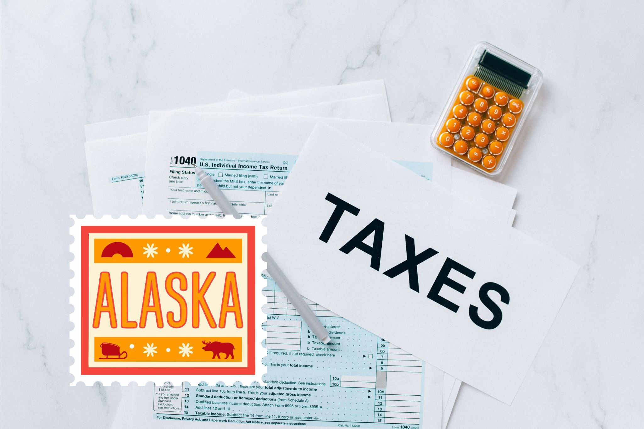 A capital gains calculator sits next to tax forms, a paper with the word 'TAXES', and an Alaska state logo on a white marble surface.