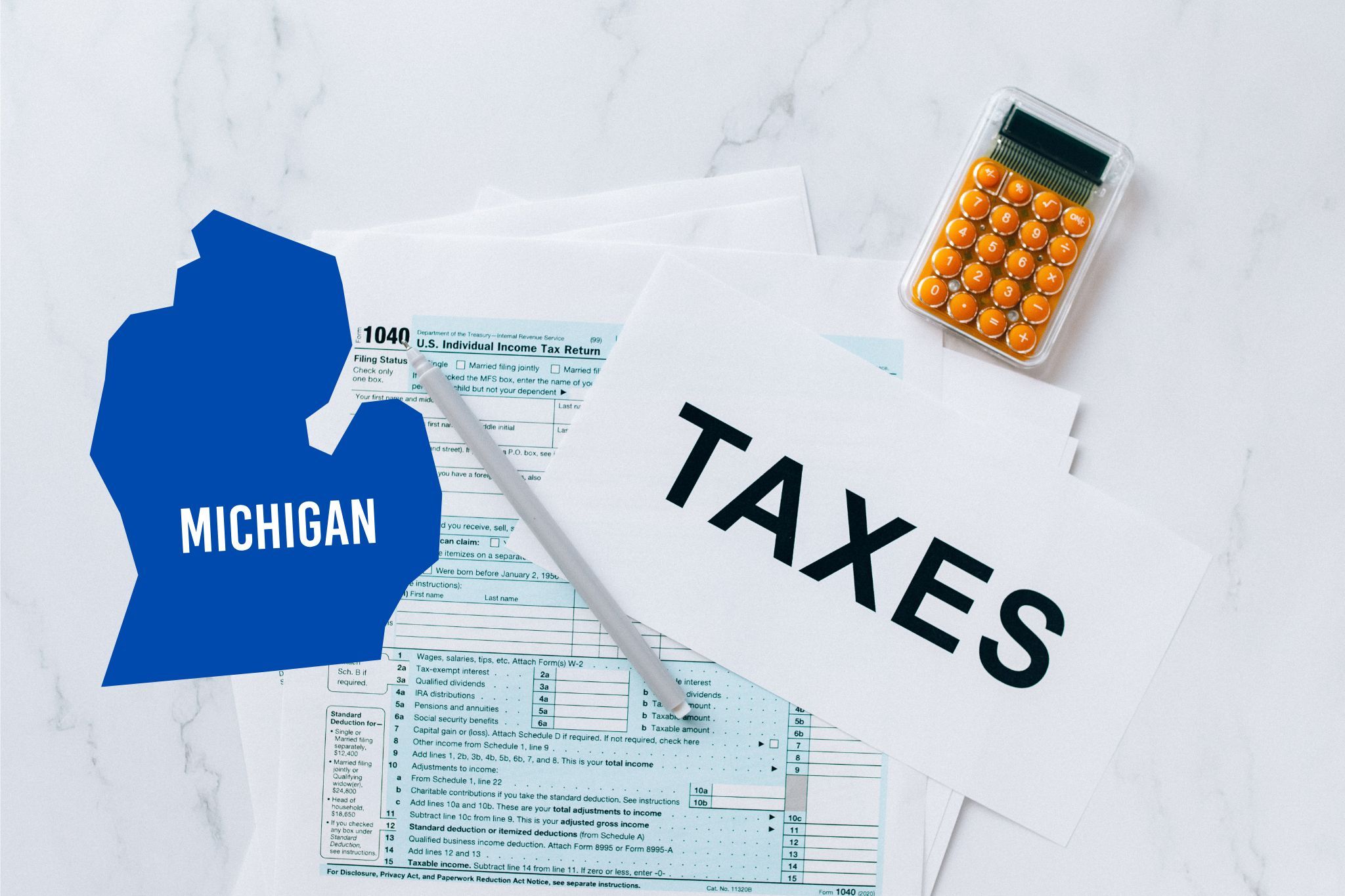 A capital gains calculator sits next to tax forms, a paper with the word 'TAXES', and an Michigan state logo on a white marble surface.