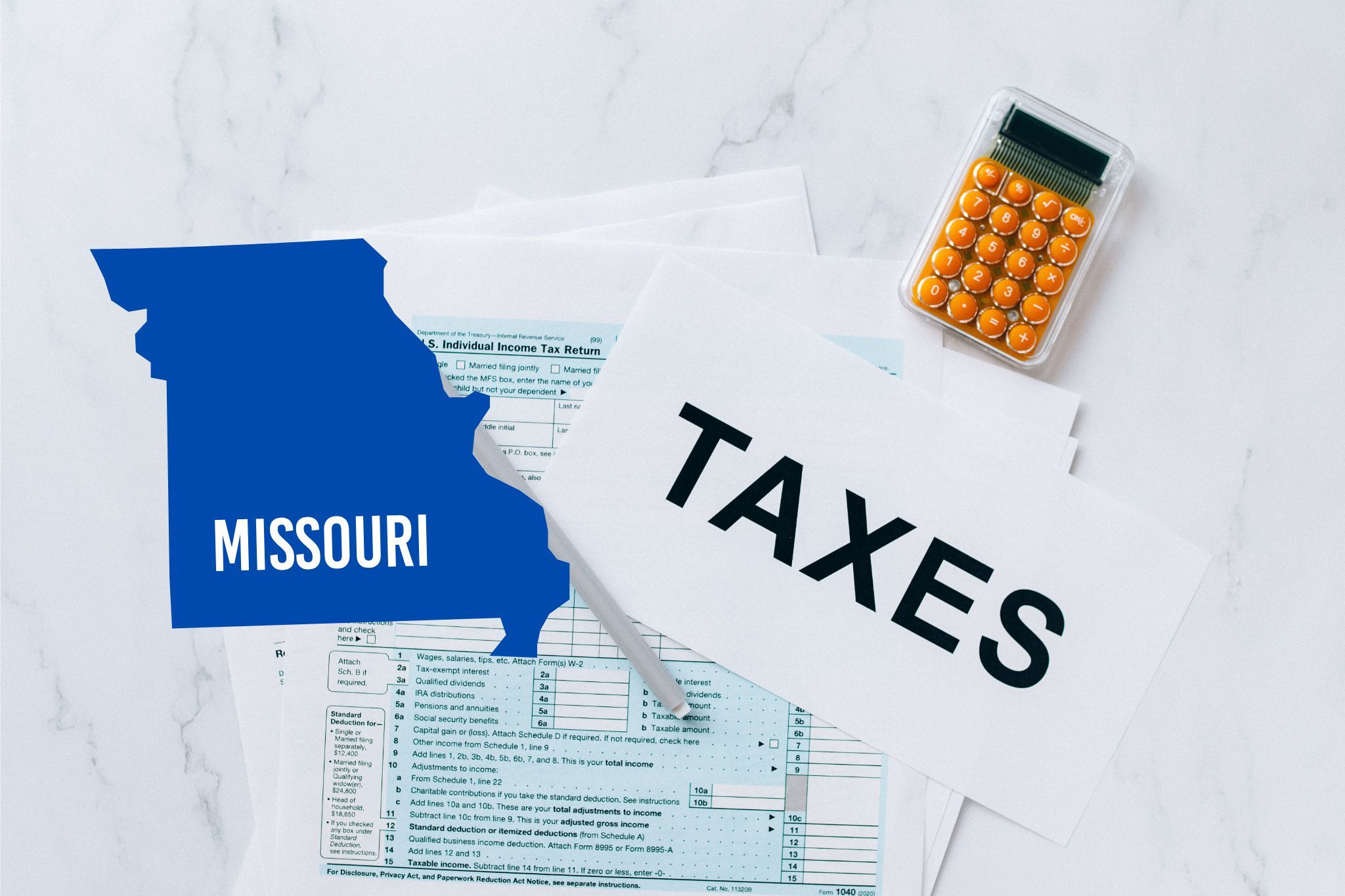 A capital gains calculator sits next to tax forms, a paper with the word 'TAXES', and an Missouri state logo on a white marble surface.