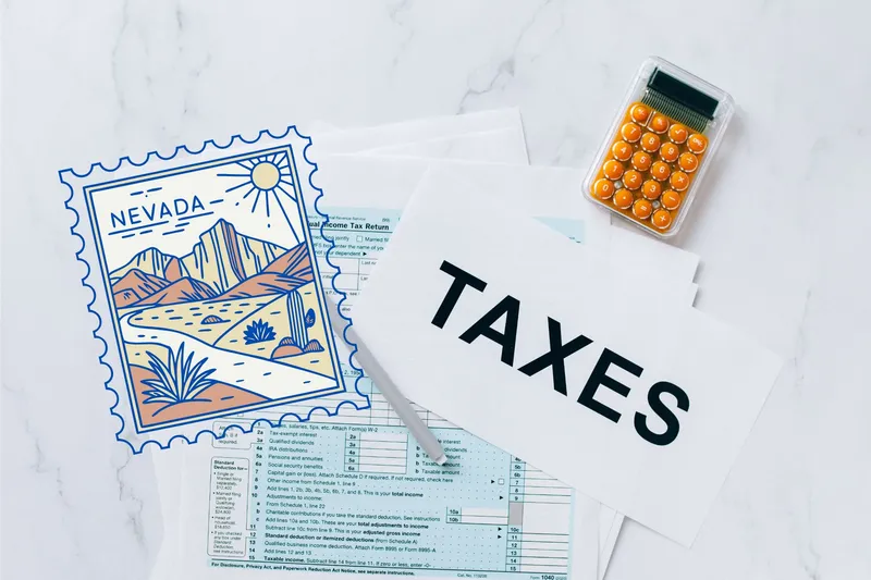 A capital gains calculator sits next to tax forms, a paper with the word 'TAXES', and an Nevada state logo on a white marble surface.