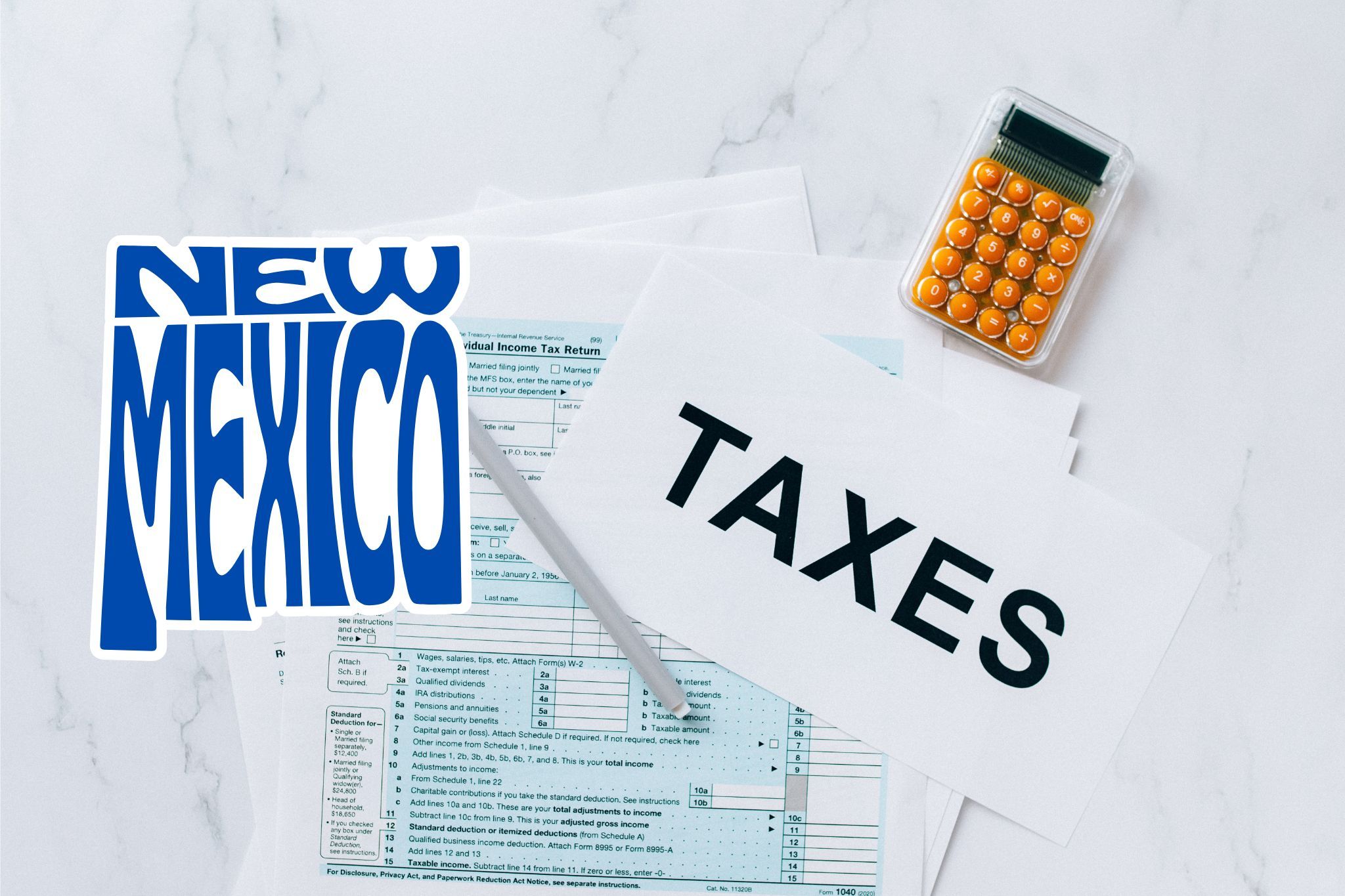 A capital gains calculator sits next to tax forms, a paper with the word 'TAXES', and an New Mexico state logo on a white marble surface.