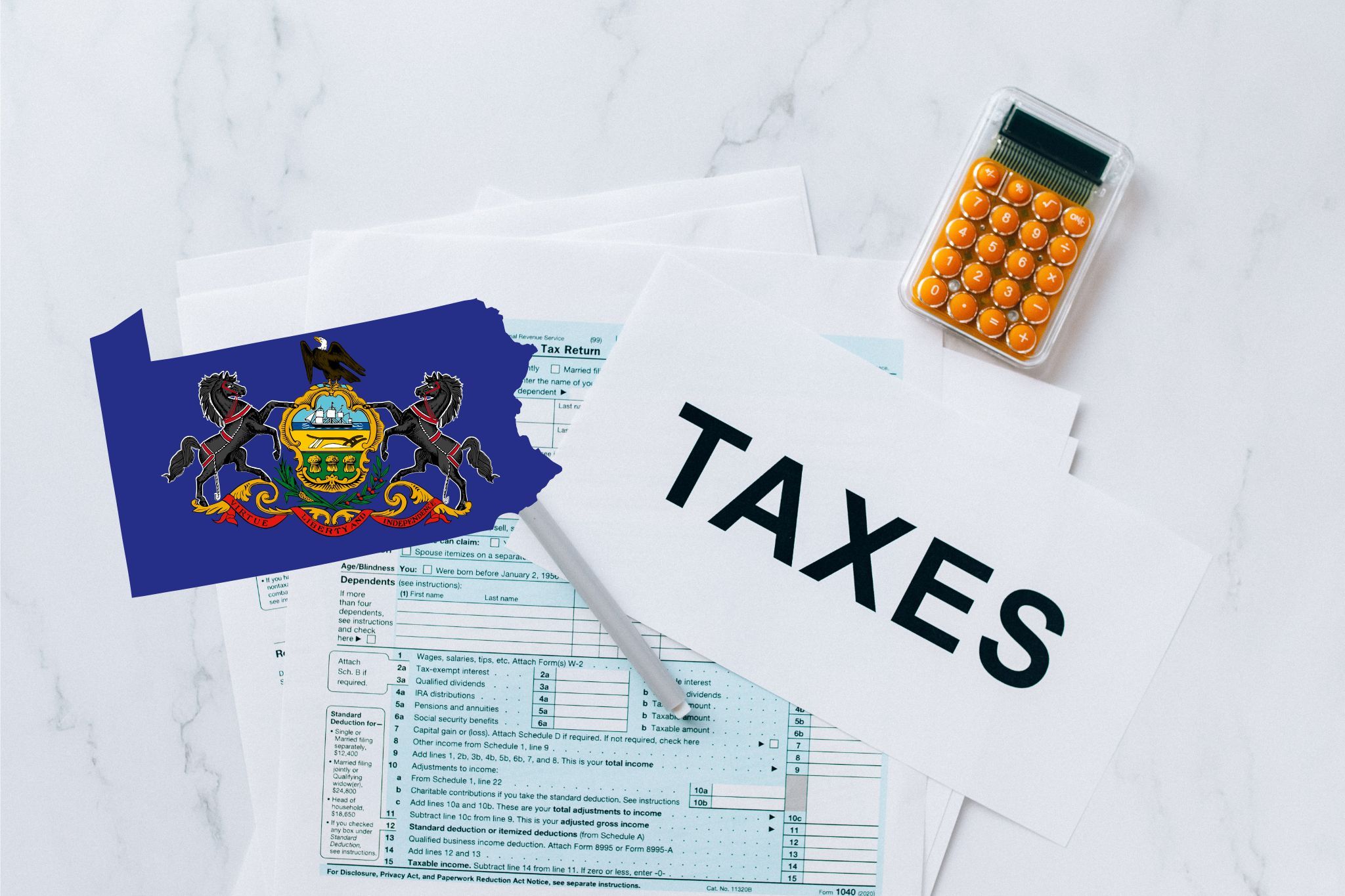 A capital gains calculator sits next to tax forms, a paper with the word 'TAXES', and an Pennsylvania state logo on a white marble surface.