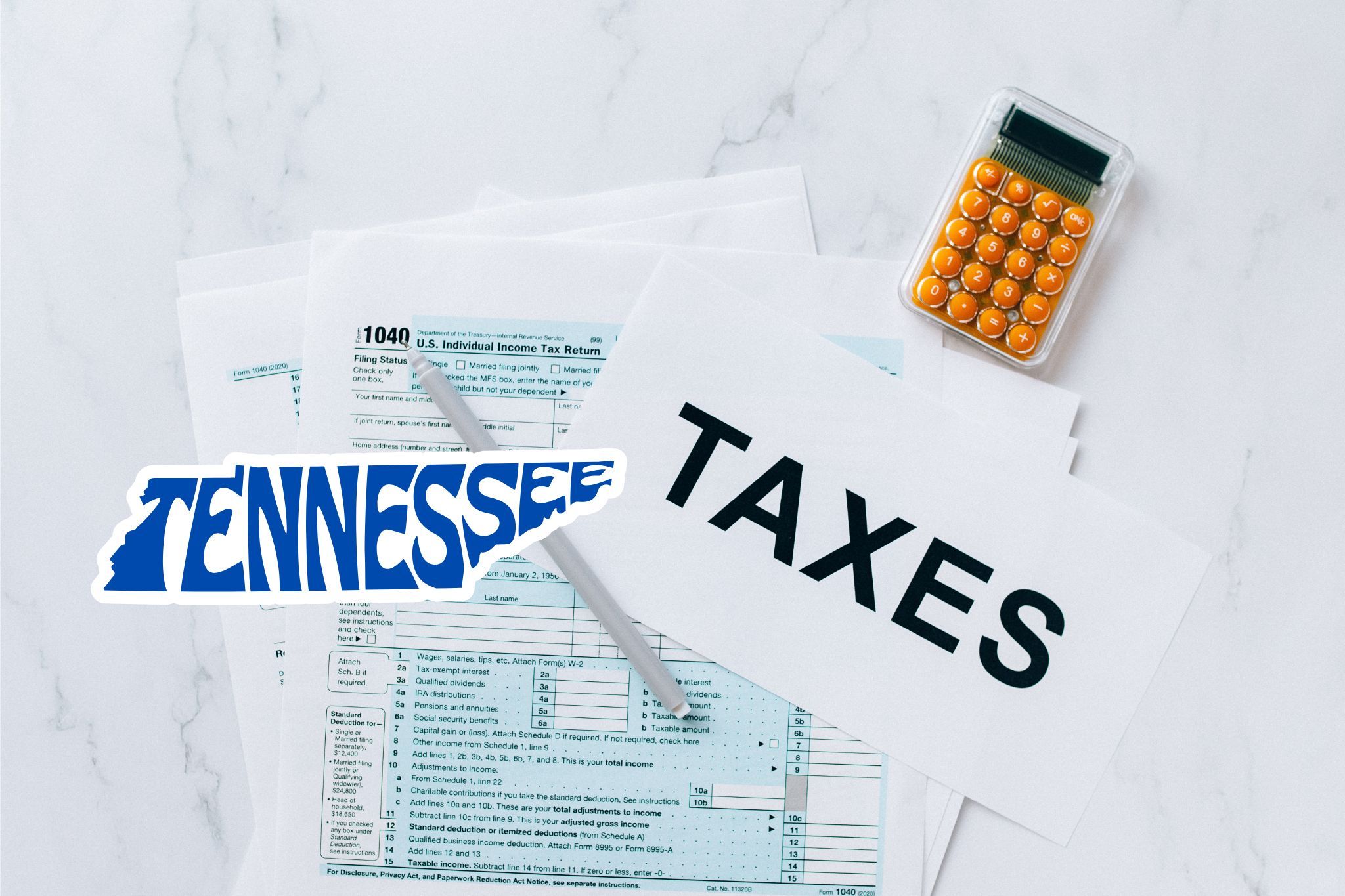 A capital gains calculator sits next to tax forms, a paper with the word 'TAXES', and an Tennessee state logo on a white marble surface.