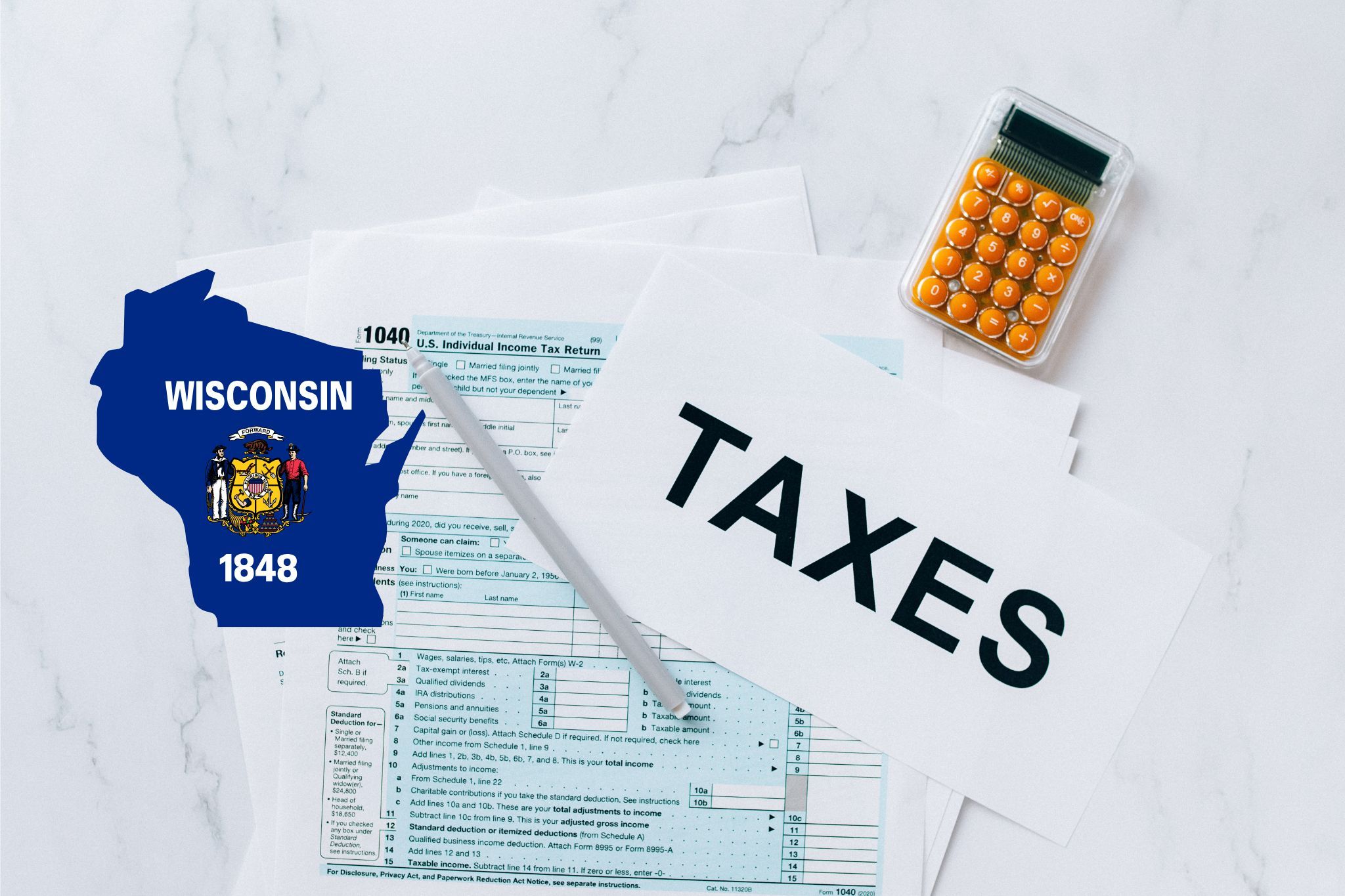 A capital gains calculator sits next to tax forms, a paper with the word 'TAXES', and an Wisconsin state logo on a white marble surface.