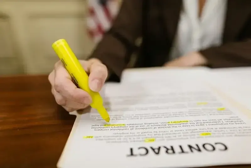 Person highlighting purchase and sale agreement