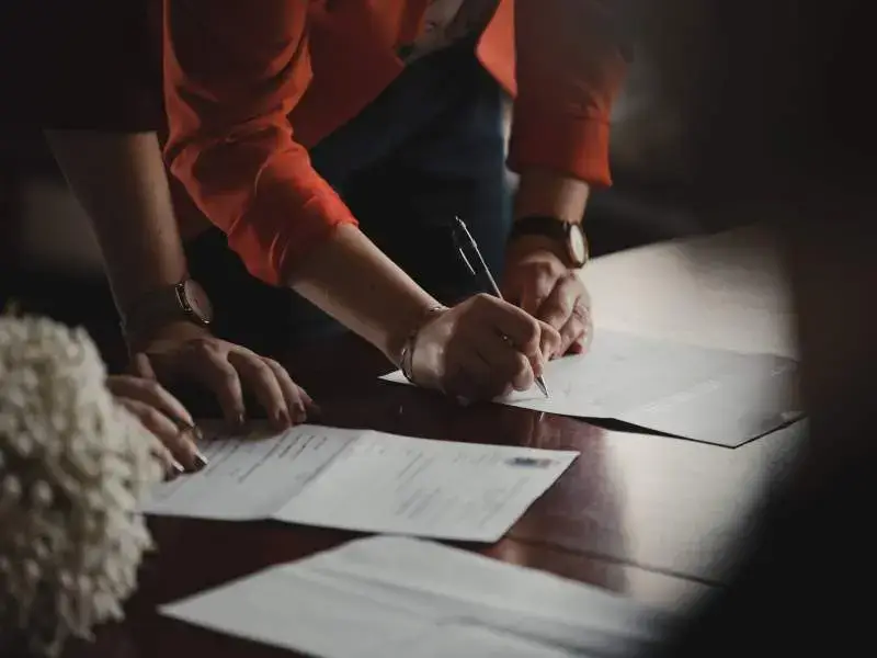 Two people signing a real estate contract
